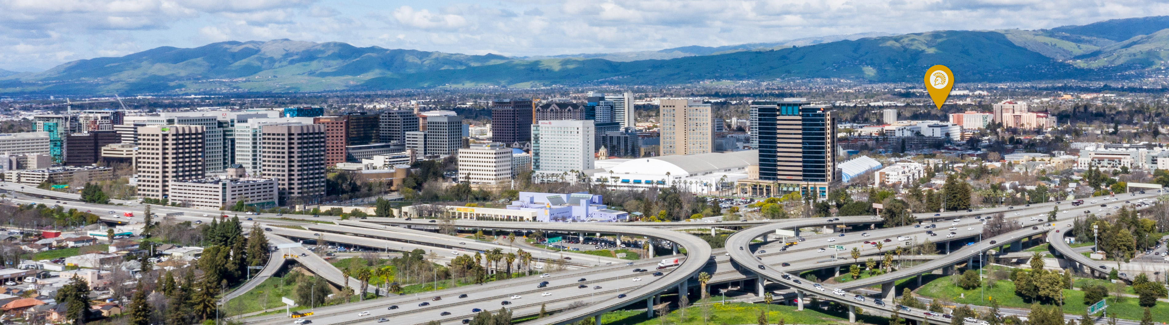 An aerial view of San Jose City with a gold spartan pin that points to the location of SJSU.