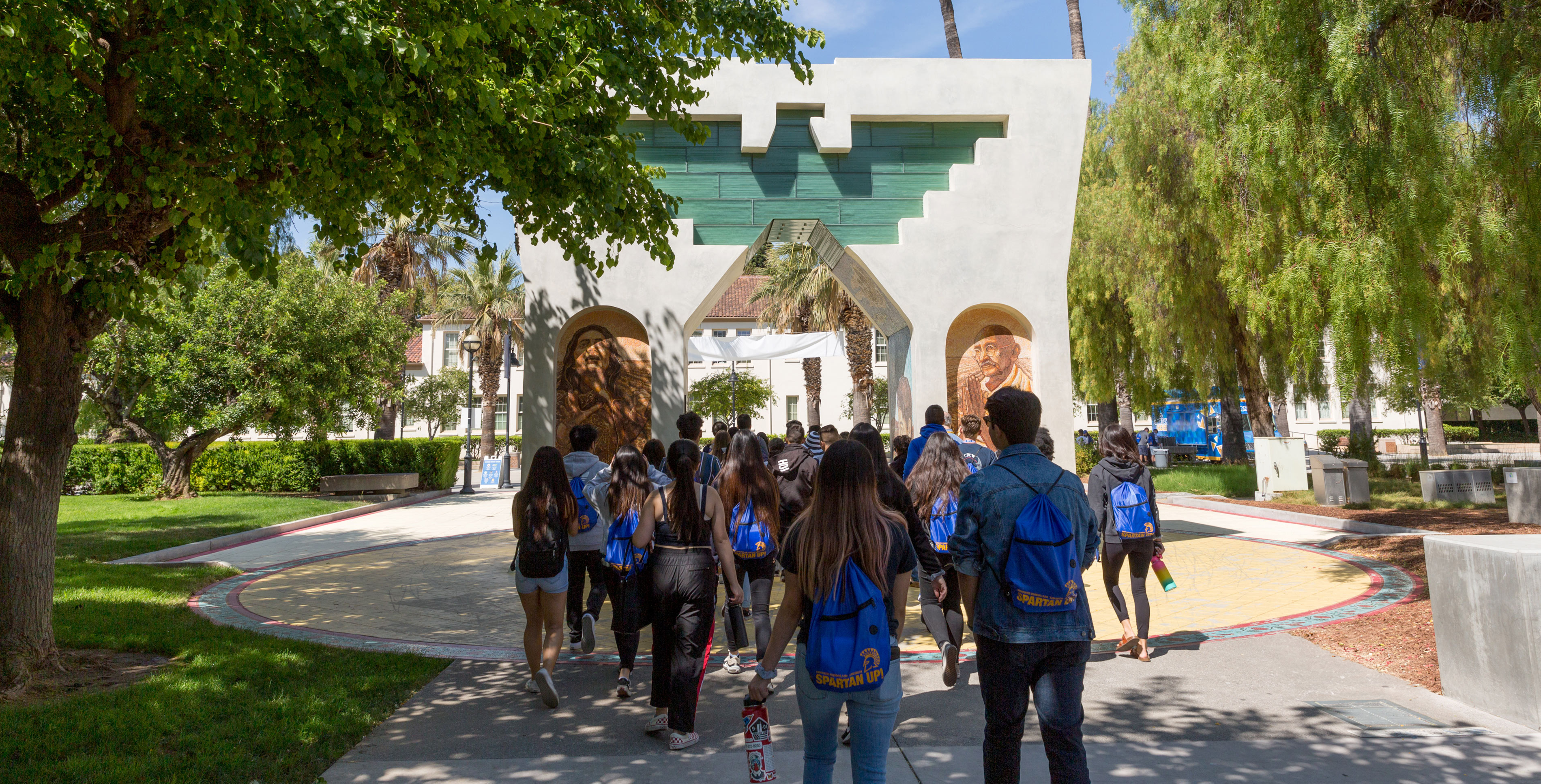 Students walking through the Cesar Chavez monument on the SJSU campus.