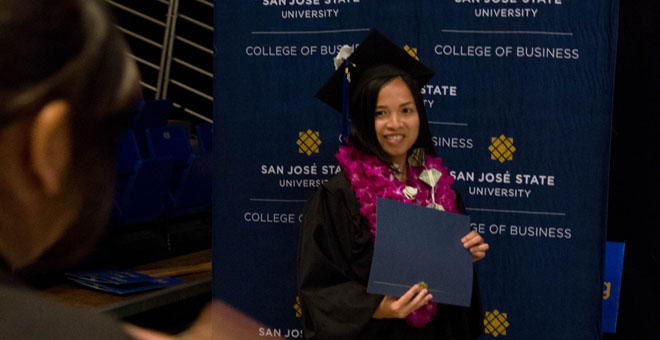 Student takes banner photo before going on stage.