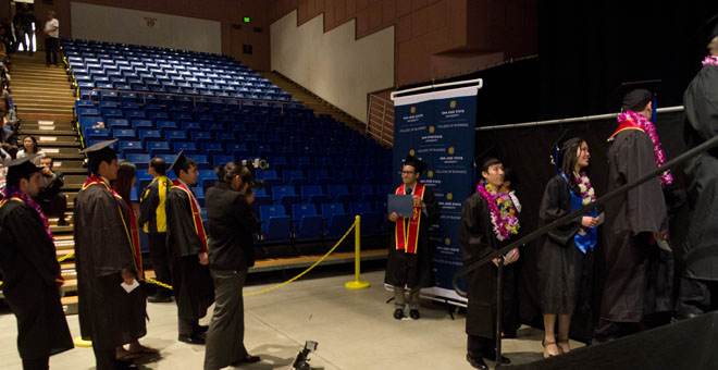 Accounting students line up for banner photo then go up on stage.