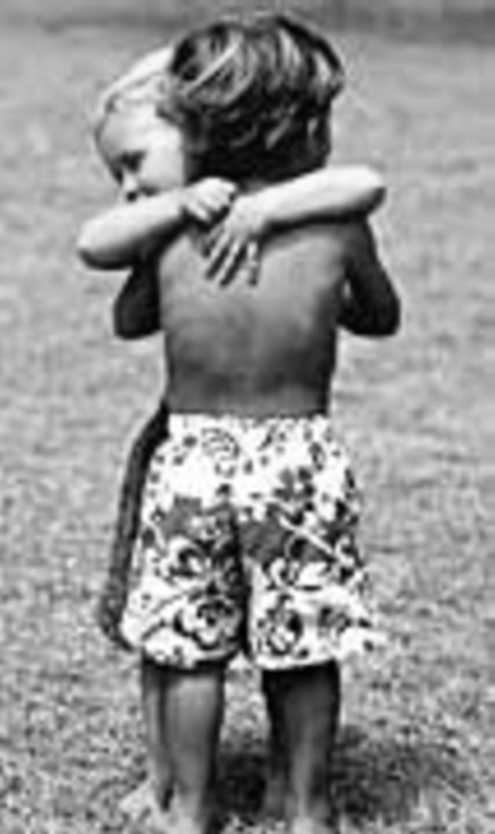 Young Black boy hugging young White boy.