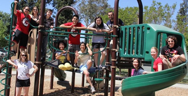 Photo of a group of students on a jungle gym in a playground.