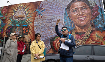 person gives tour near mural of ancestor