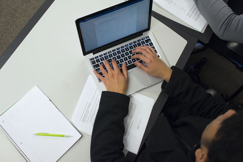 Overhead view of student working on their laptop.