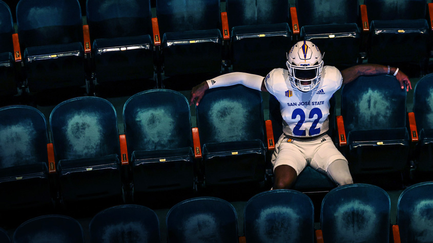A SJSU football player sits in the hammer theatre.