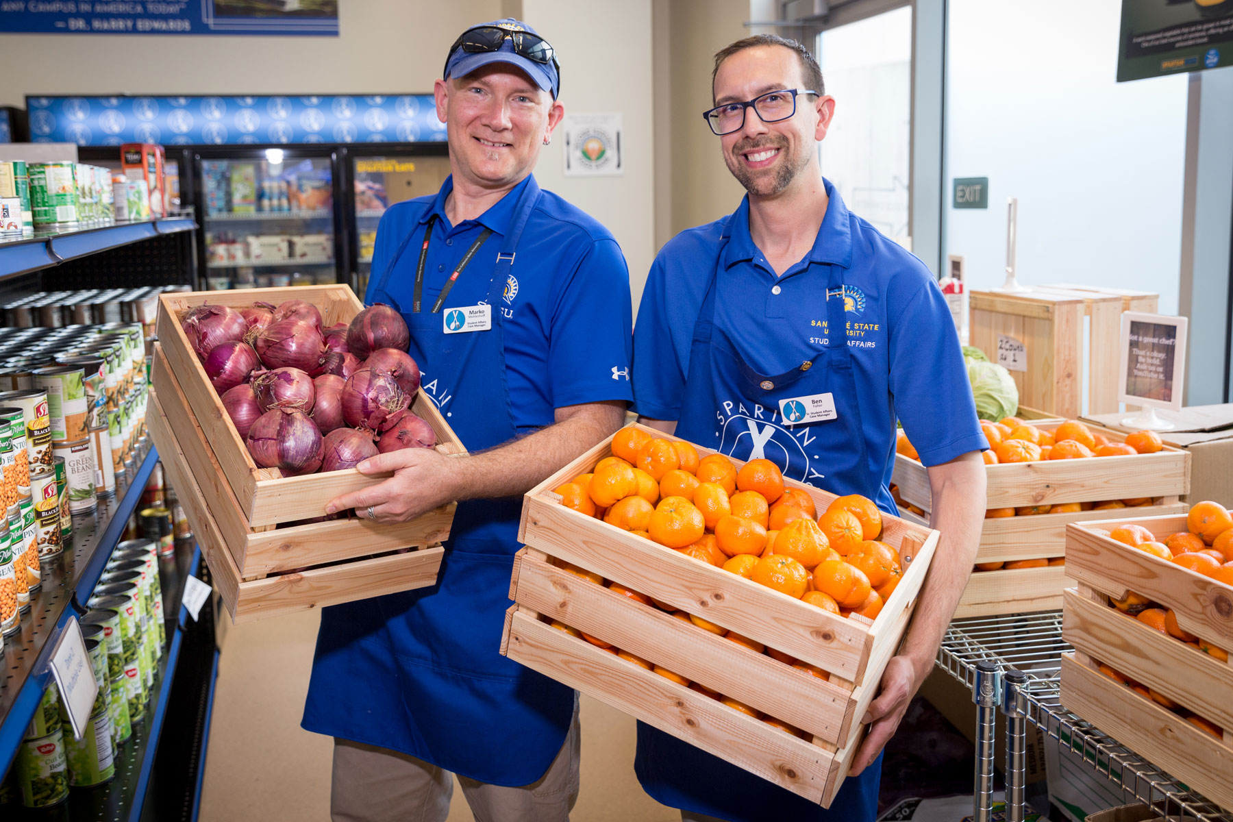 SJSU Cares staff holds fresh produce offerings from the Spartan Food Pantry.