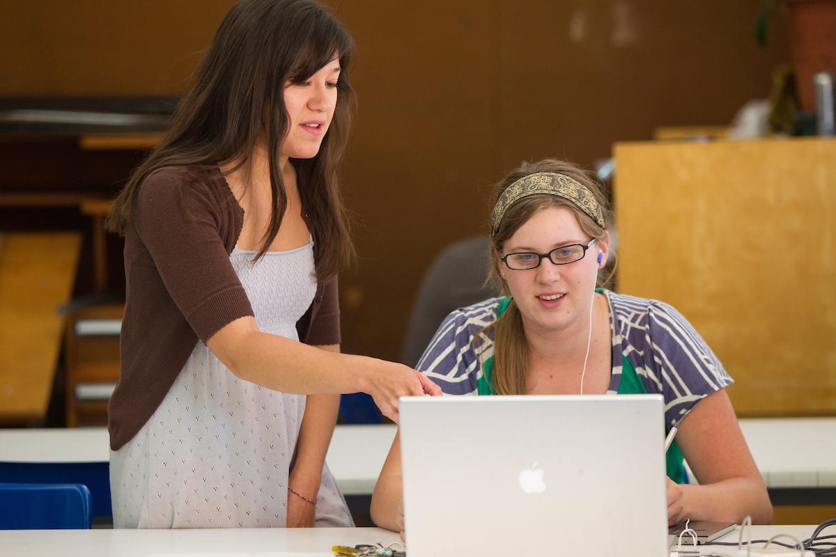 Two female sjsu students work together on a laptop