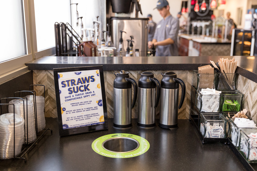 A sign that says Straws Suck, grab our compostable lid.