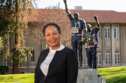 Black female in suit in front of Victory statue at San Jose State University