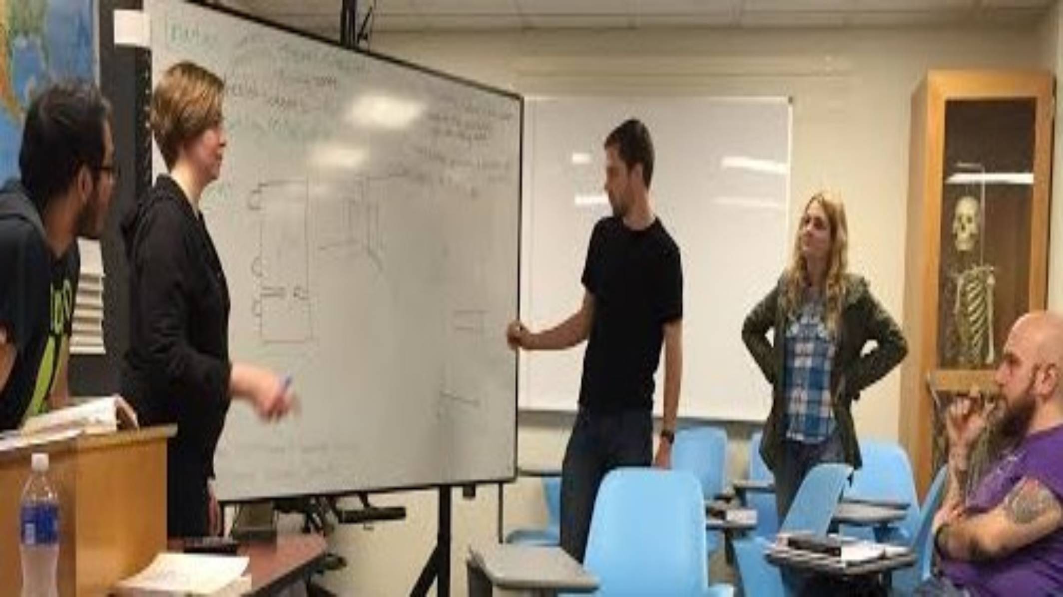 Anthropology students working at a white board