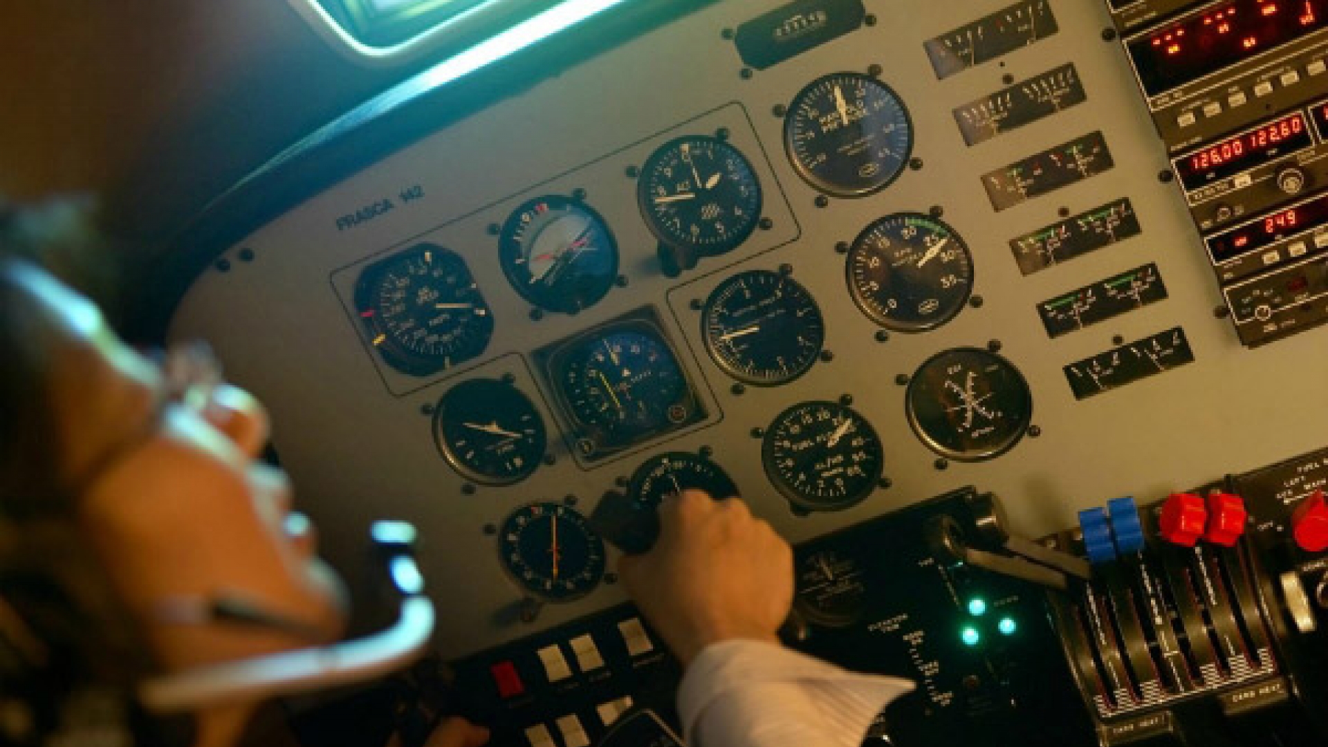 Student in the cockpit adjusting dials.