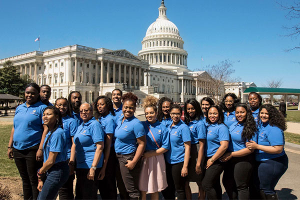 Students and staff members pose in front of the U.S. Capitol building.