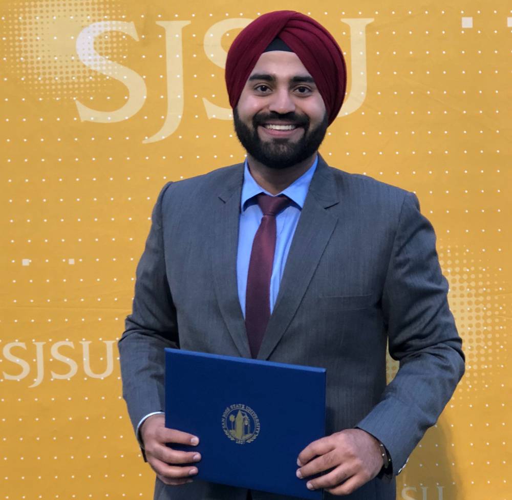Ramneet Singh poses in front of a yellow SJSU background.