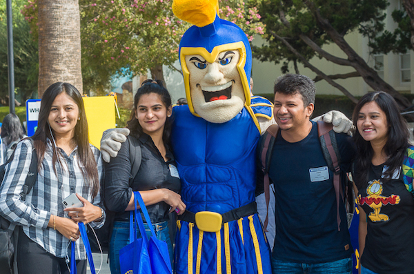 three students with Spartan mascot