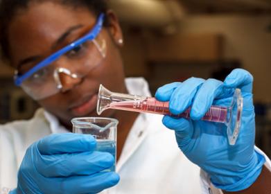 Biomedical engineering student pours liquid into a vial
