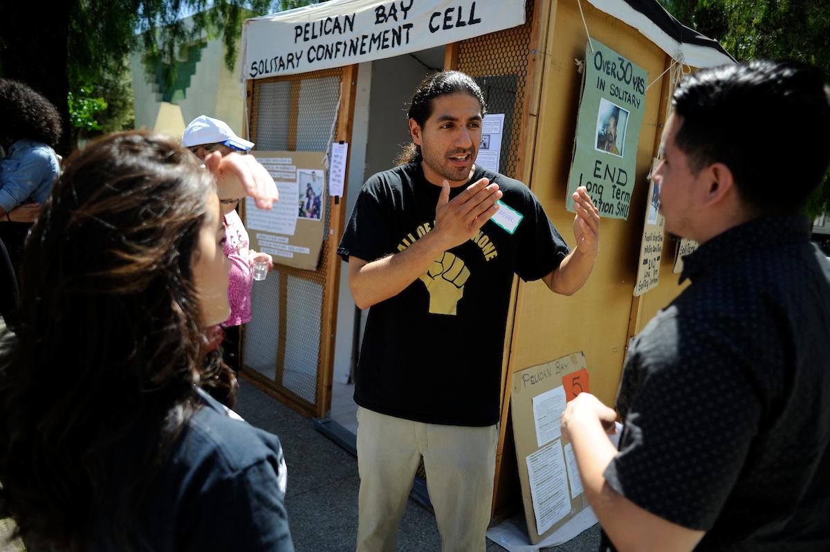 Student discusses Pelican Bay Solitary Confinement Cell with a group.