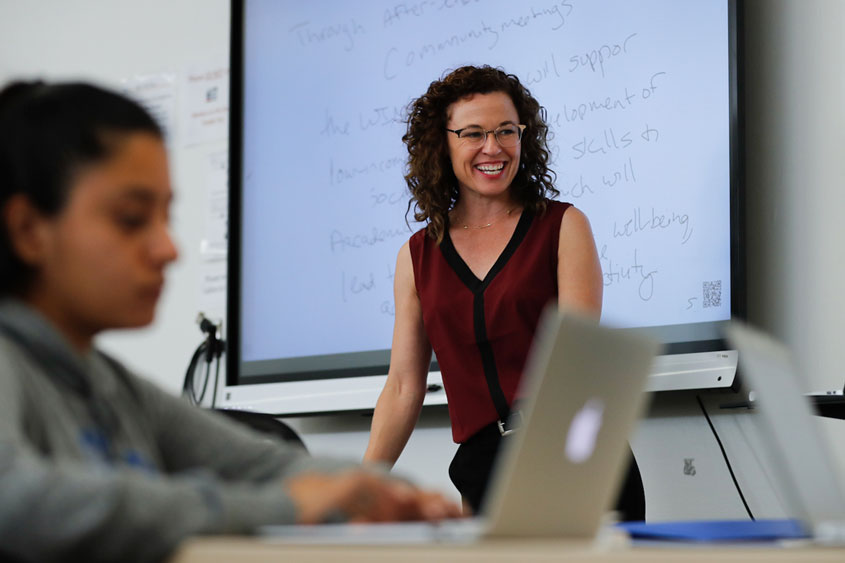 Professor is teaching in a classroom.