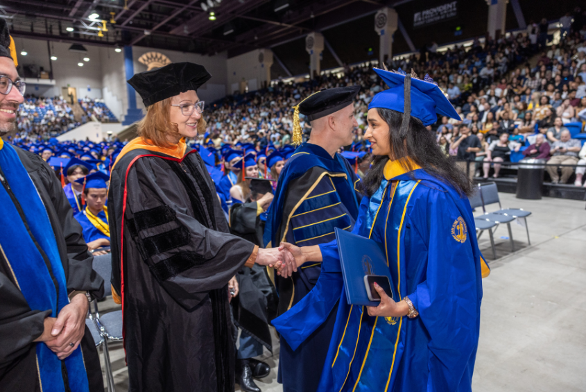 Graduate shaking hands with a faculty member