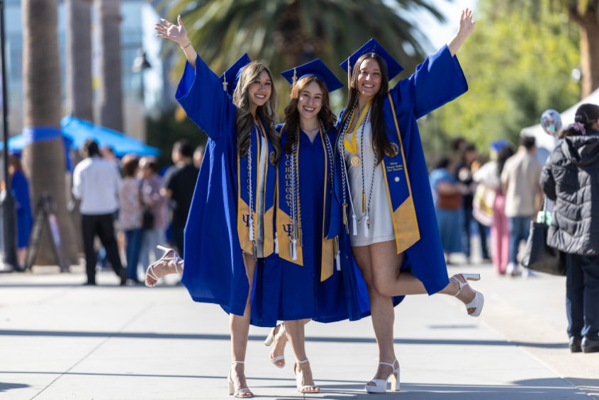 Graduating students posing with gowns and high heels