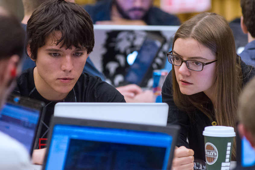 Male and Female student looking at a laptop.