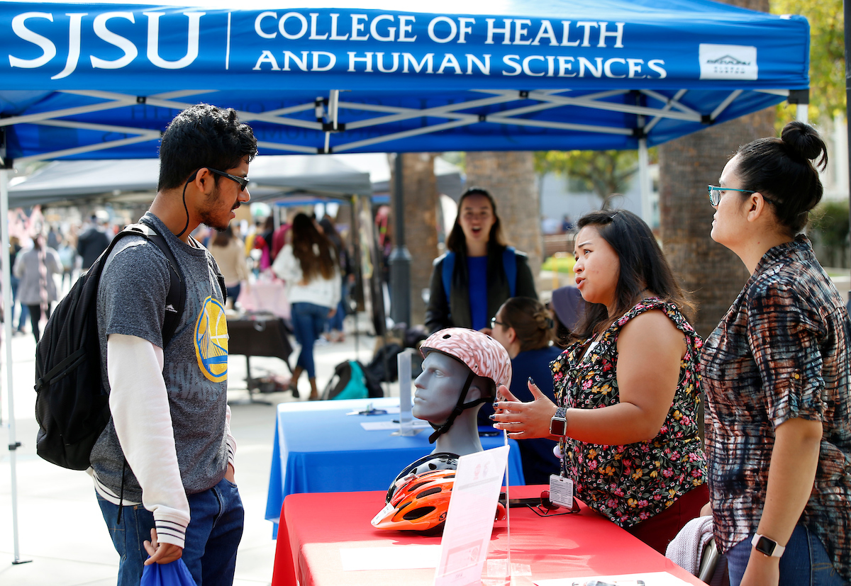 Student visiting a health fair booth and getting information.