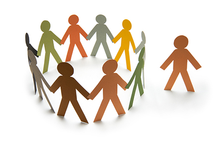 a circle of paper people of different colors holding hands with one unattached paper person on the outside of the circle.