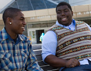 Two students in conversation while smiling.