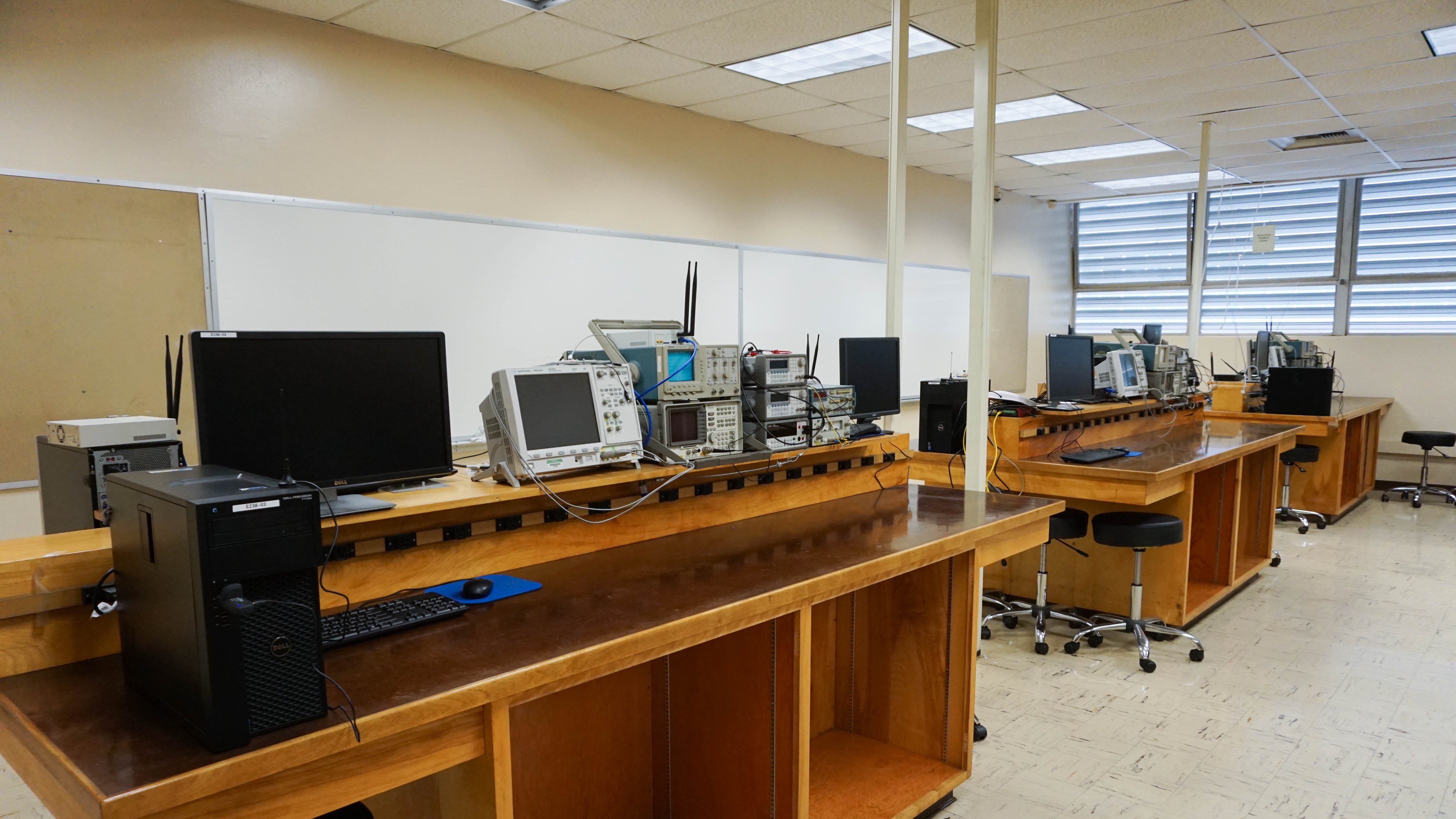 A lab with electronics equipment and wooden stations.