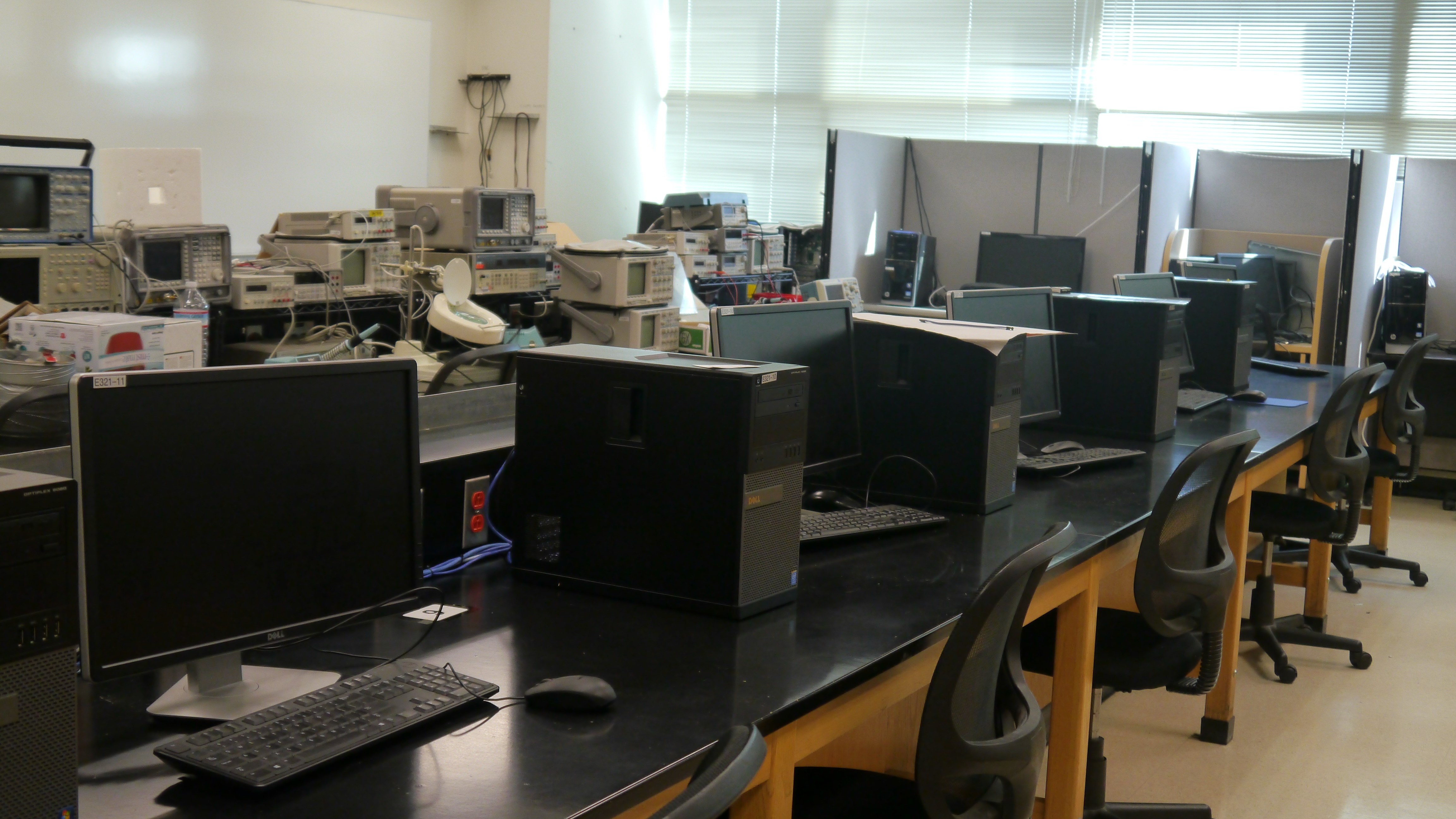 A few black computer stations inside a dimly lit laboratory.