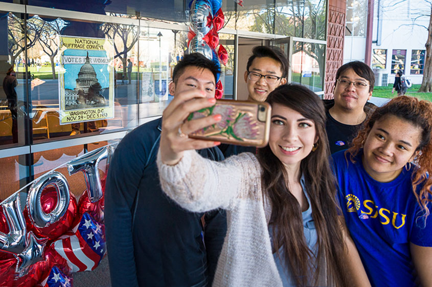 Students huddling for a selfie after voting.