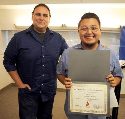 happy student displaying a scholarship they received.