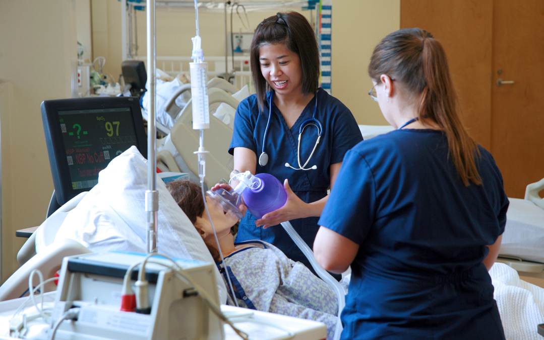 Nursing students practice giving oxygen to a dummy.