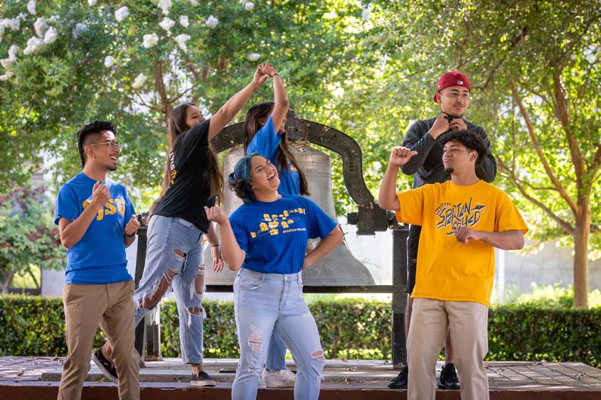 Students making fun poses together on campus.