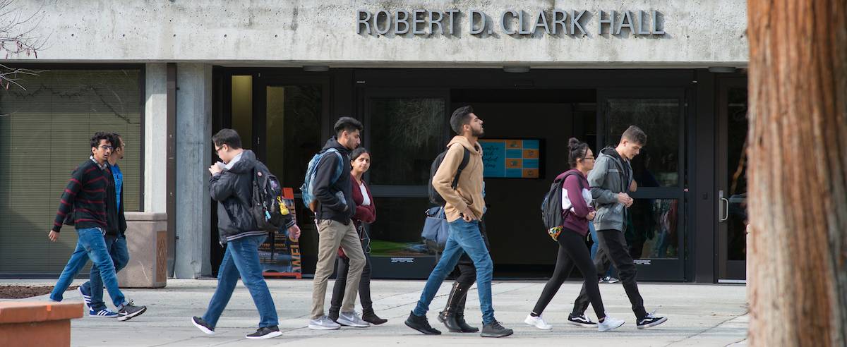 photo of the front of clark hall, students walking by