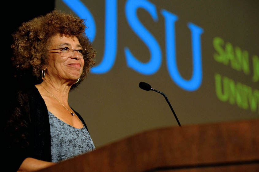 Dr. Angela Davis smiling behind a podium.