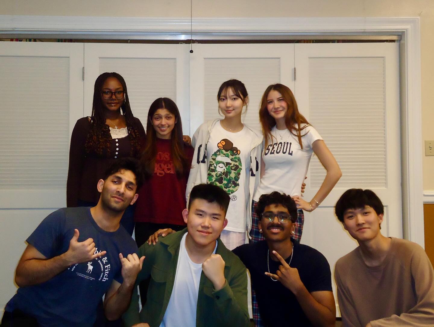 A cohort of ethnically diverse students in casual clothing standing together for a group photo