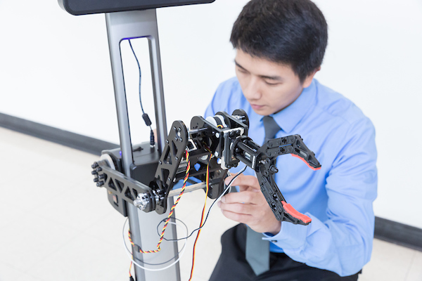 Student adjusting a robotic arm