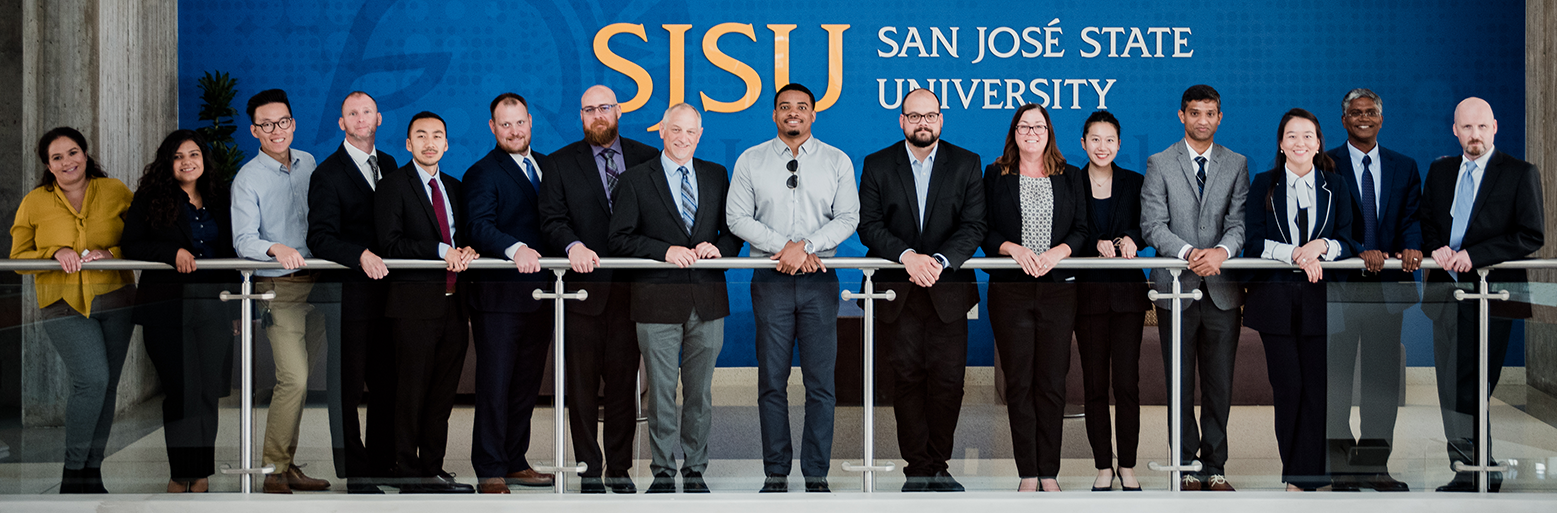 Business Students together posing in front of SJSU wall
