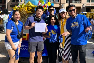 A group of international students stand in front of a building at San José State University.