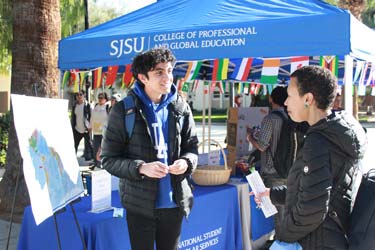 An international student talking to one of the International Gateways instructors on a Global Spartan tabling event.
