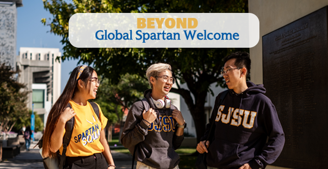 Beyond Global Spartan Welcome - three students wearing university garb talk with one another