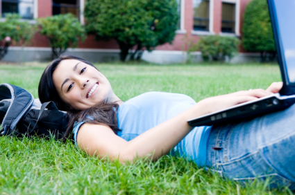Student with laptop in grass