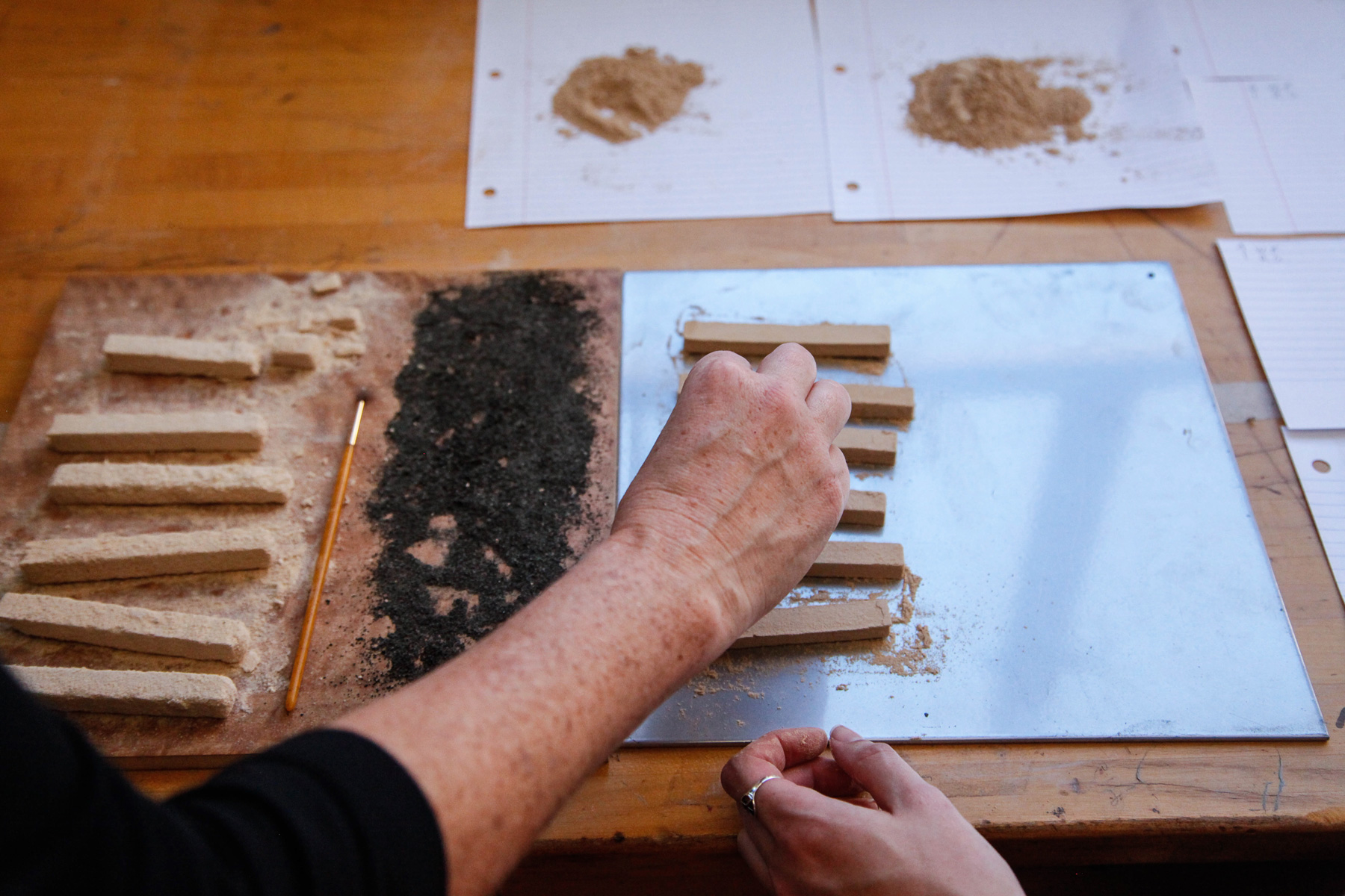 On a wooden desk lays a display of 3D printed rectangular clay.