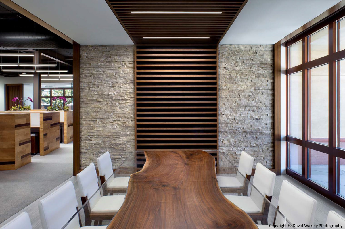 Conference room table made out of a sliced portion of a tree trunk and surrounded with white cloth chairs.