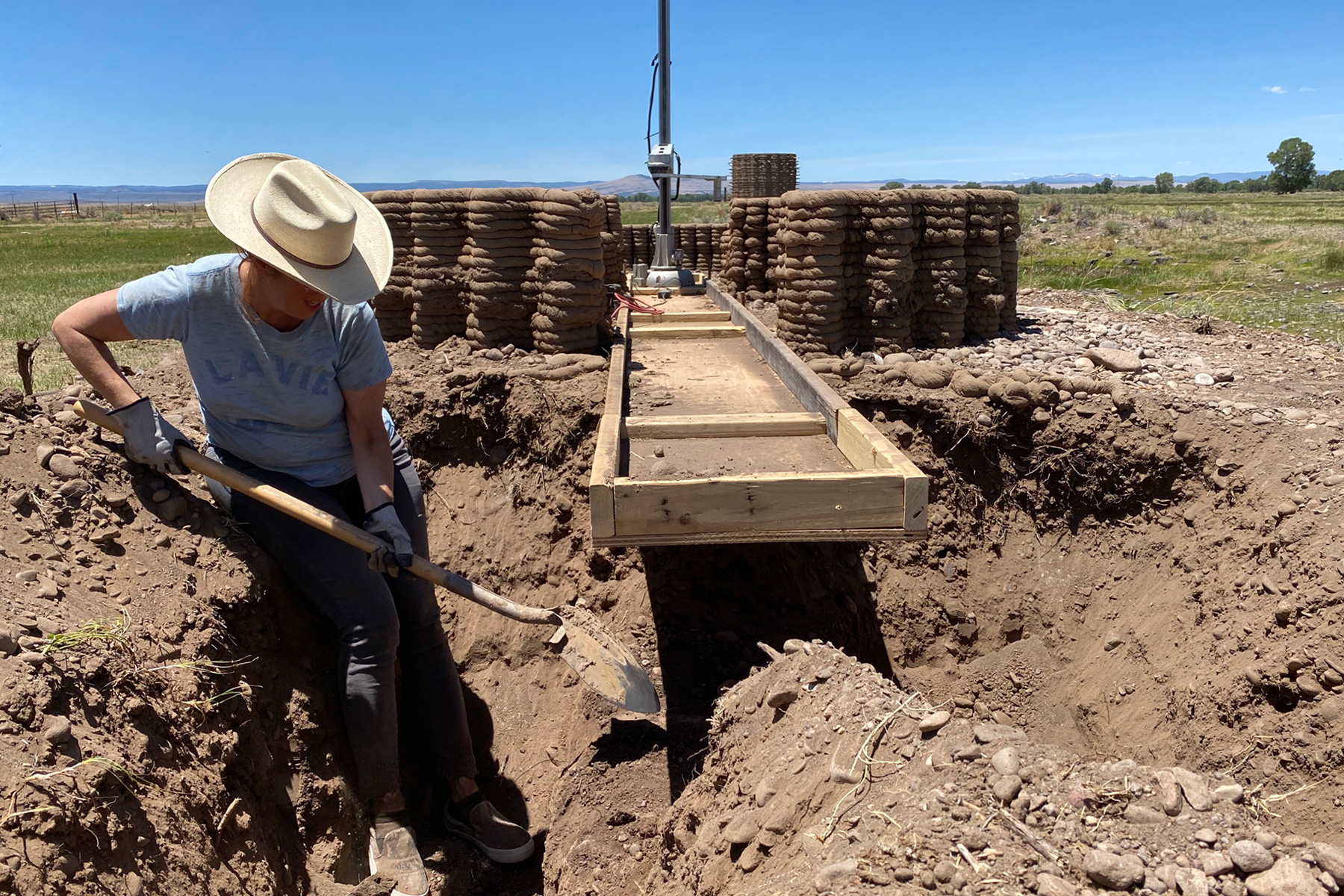 San Fratello excavating onto a belt that leads to the robotic arm that shapes the dirt.