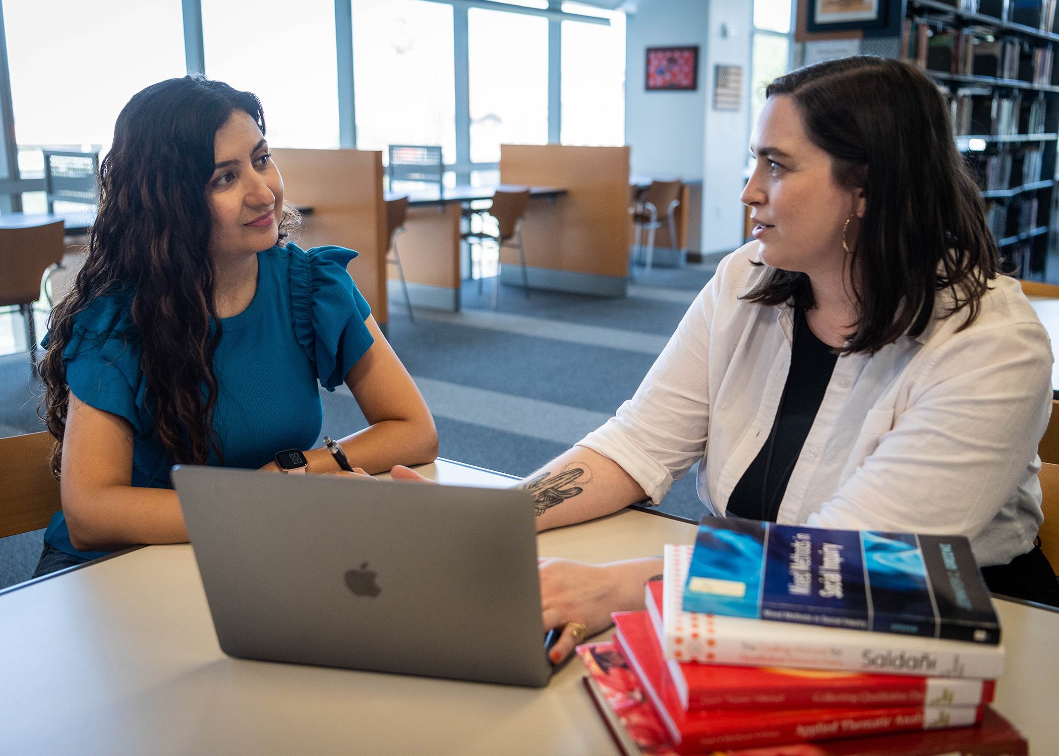 A student and librarian talking inside King Library.