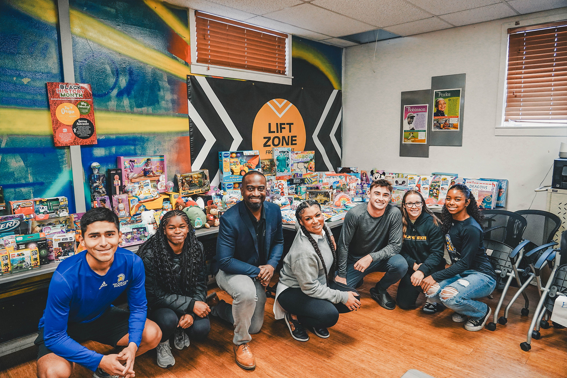 Several SJSU student athletes pose in front of their collected donations for community service toy drive. SJSU athletics, student athlete, community service, Spartans, Beyond Sparta