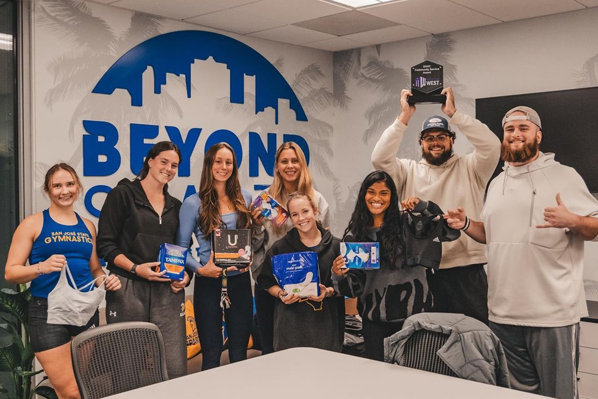 SJSU student athletes pose with sanitary products as part of their community service sanitary product drive. SJSU athletics, student athlete, community service, Spartans, Beyond Sparta