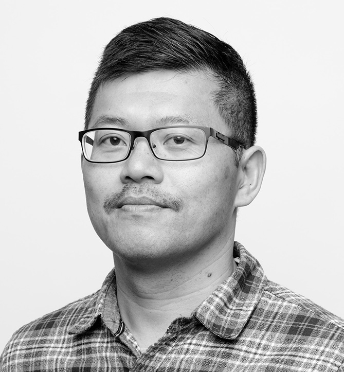 Vietnamese American man in glasses in a plaid shirt. Binh Danh, SJSU professor, photographer, artist