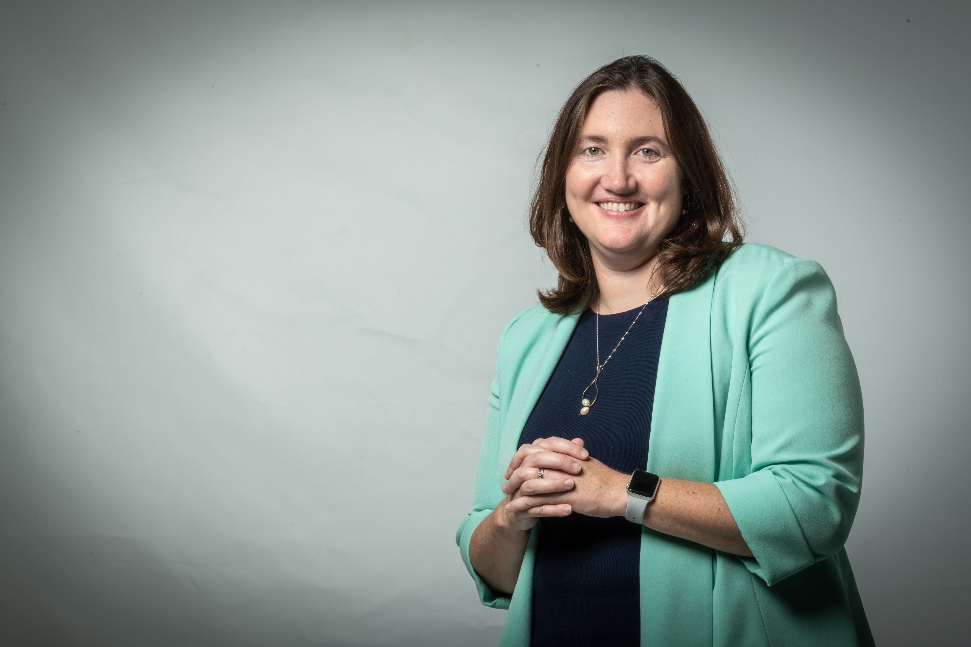 portrait of Katie Wilkinson, professor of biological sciences, wearing green jacket in studio. patents, biology, SJSU College of Science, neuropathy, innovation